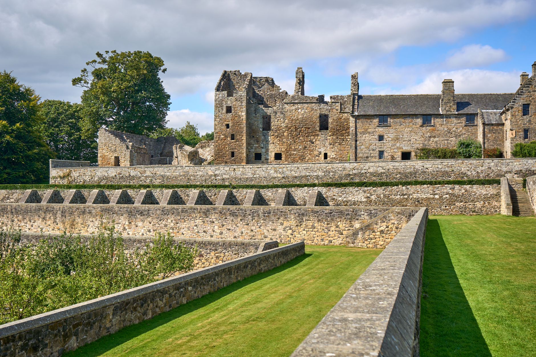 Explore the historic ruins of Aberdour Castle basking under a clear summer sky.