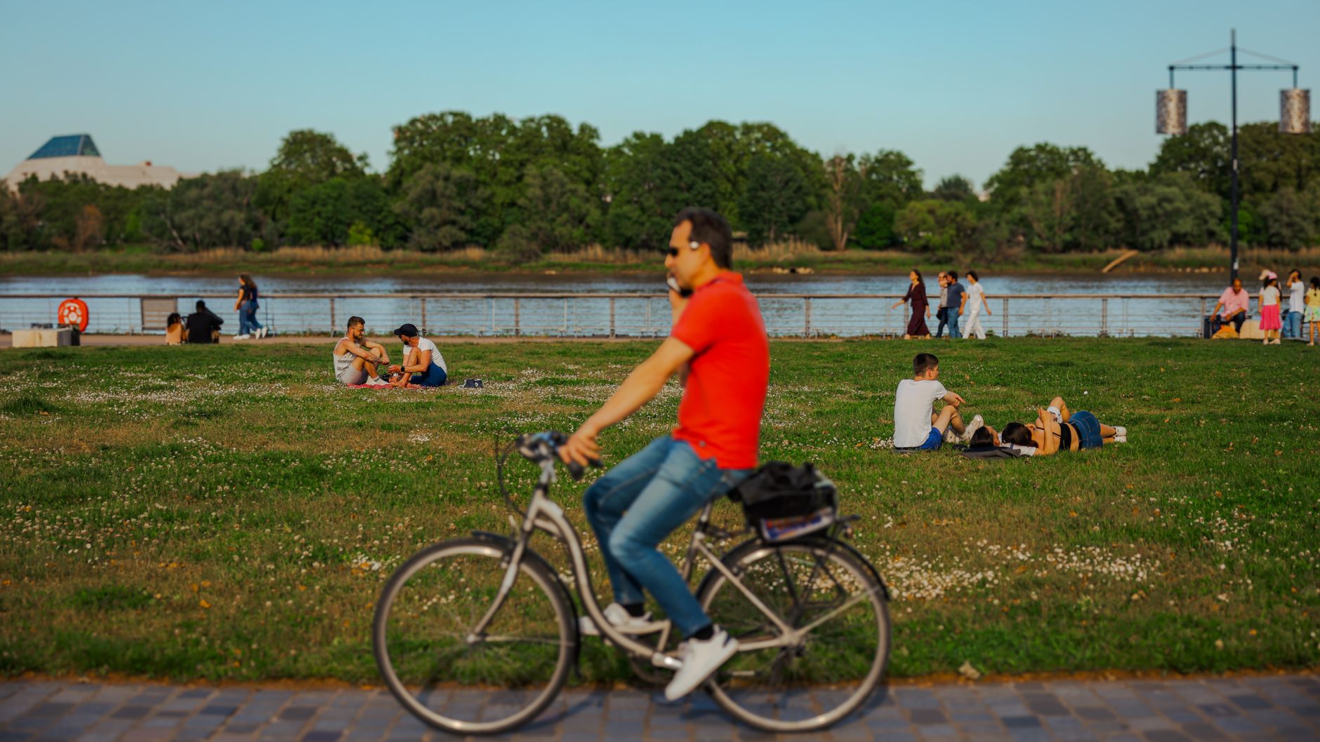 People relaxing and cycling by the riverside in Bordeaux, France.