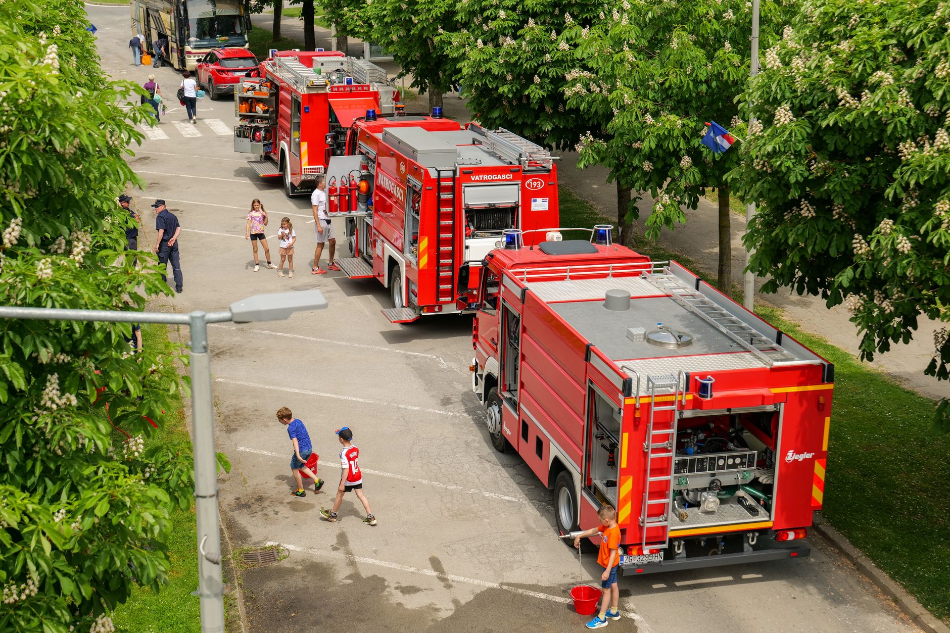 Aerial view of fire trucks and people at a park event in Garešnica, Croatia.