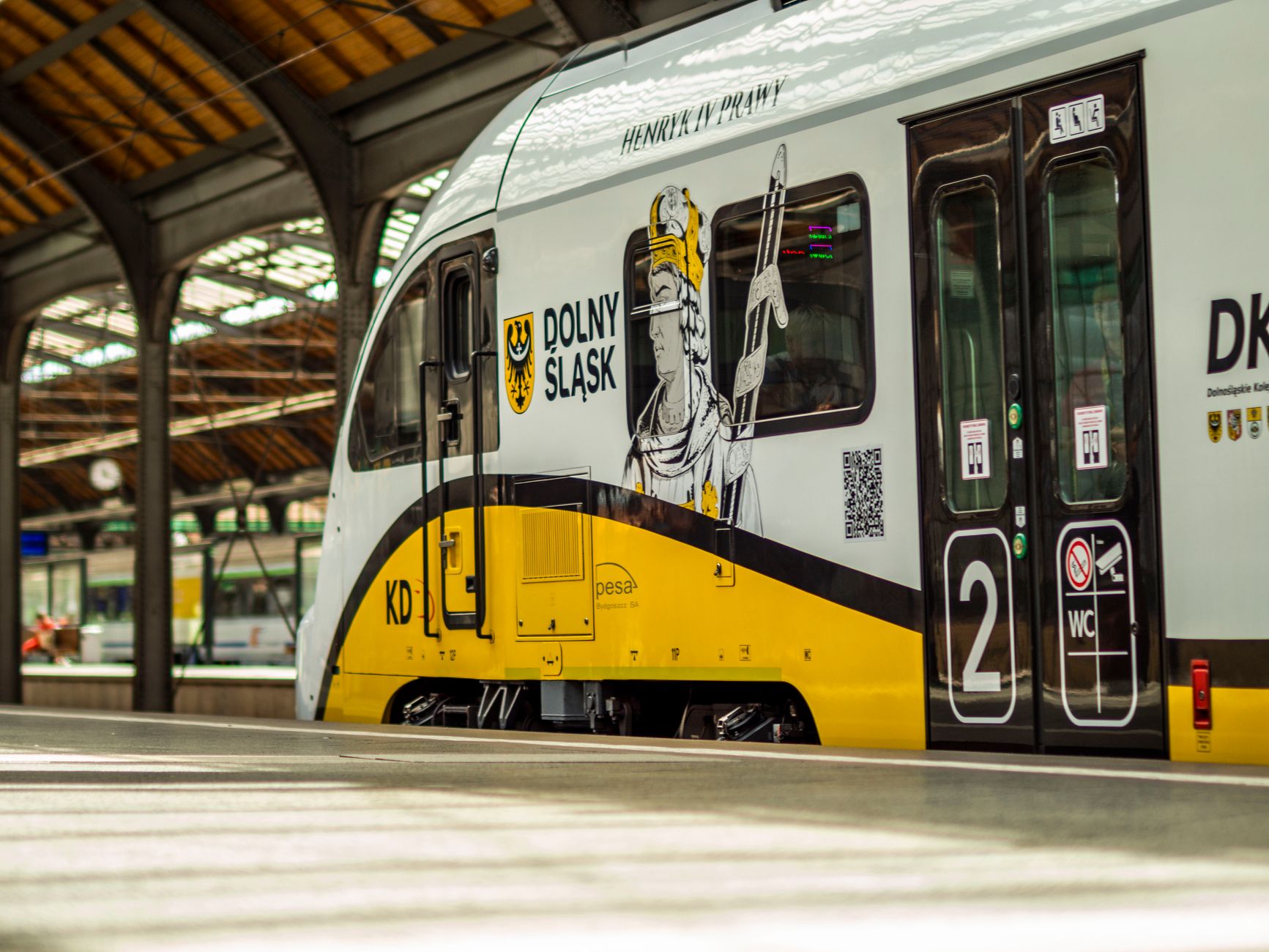 Colorful Dolny Śląsk Train in Wrocław Główny Station showcasing modern Polish rail design.