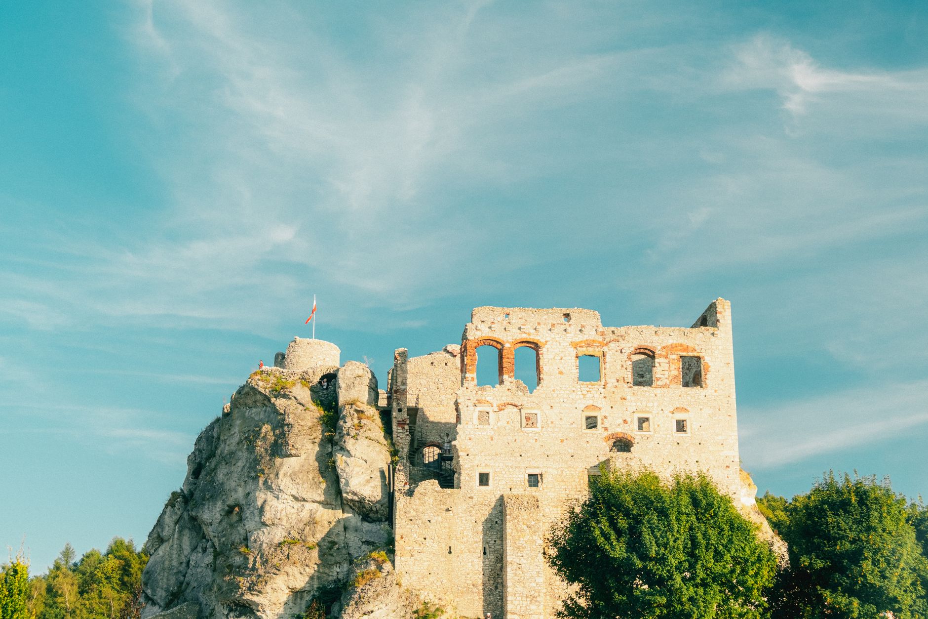 Scenic view of Ogrodzieniec Castle ruins against a blue sky during summer.
