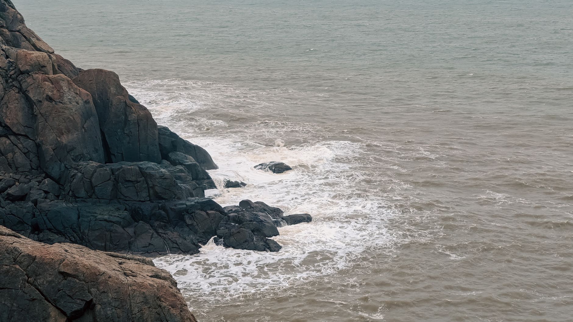 Serene view of rocky cliffs meeting the ocean in Da Nang, Vietnam, showcasing natural coastal beauty.