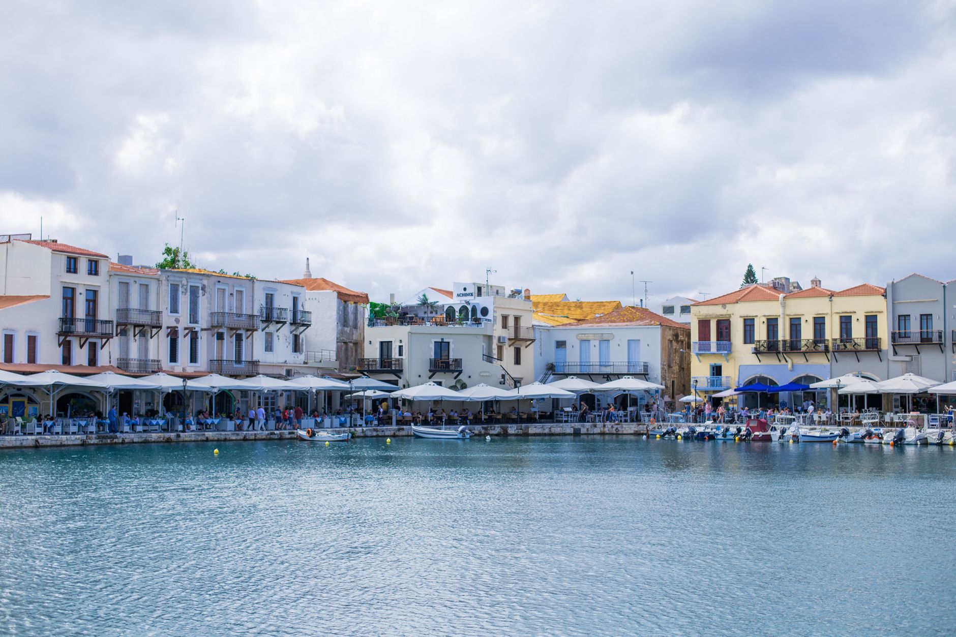 Charming waterfront with colorful buildings and peaceful harbor in Rethymno, Greece.