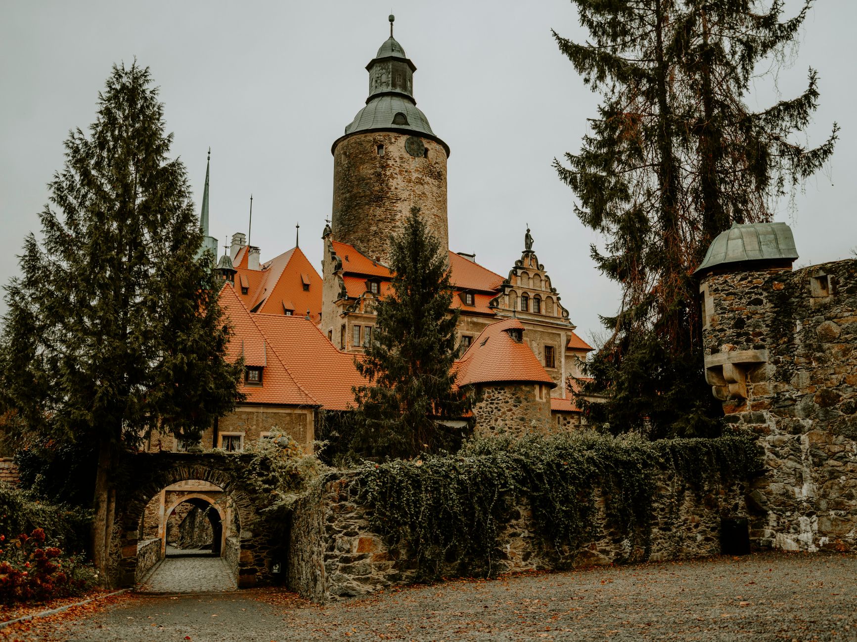 Historic Czocha Castle in Leśna, Poland, featuring medieval architecture surrounded by lush greenery.