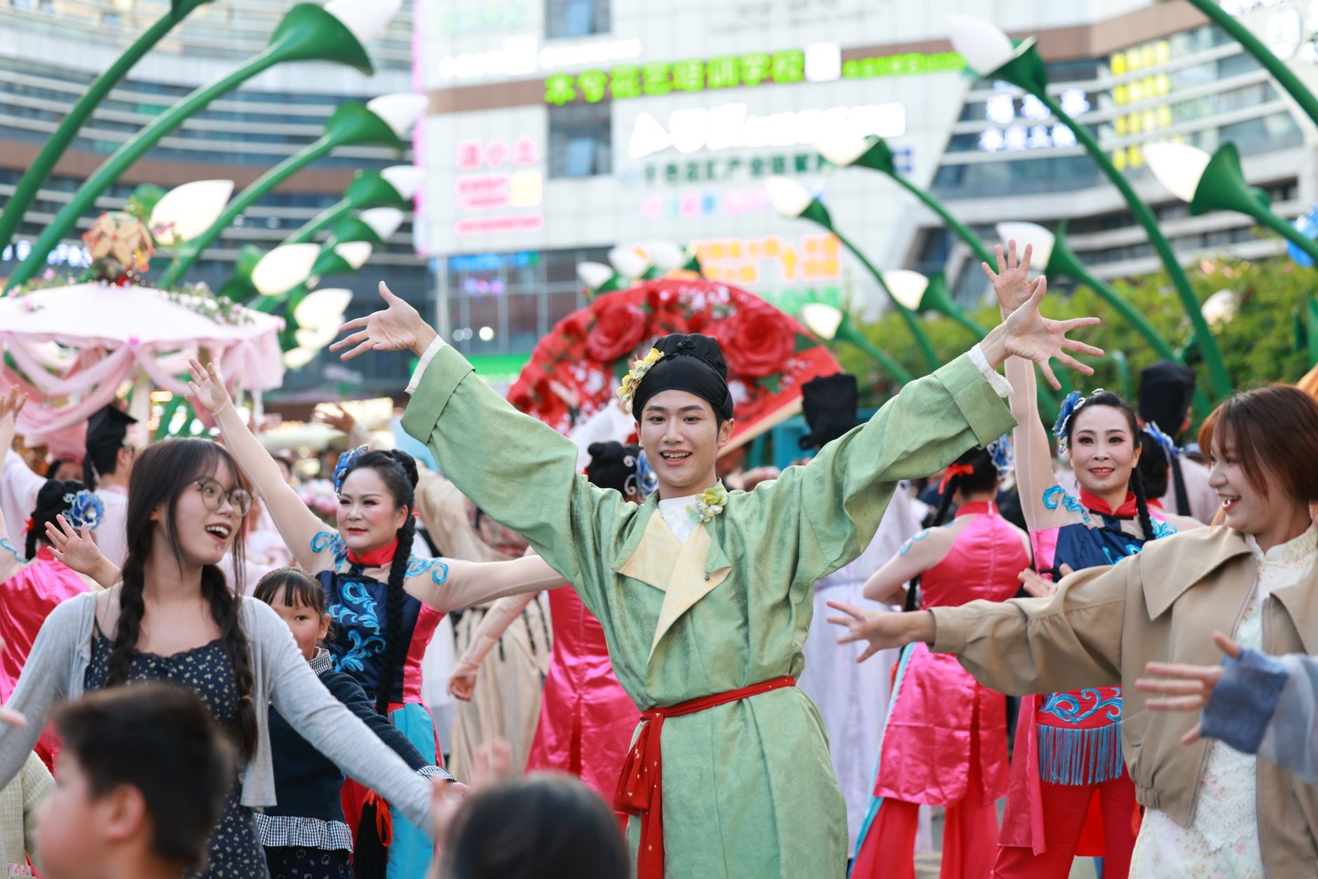 Vibrant street festival with people in traditional costumes dancing joyfully outdoors.
