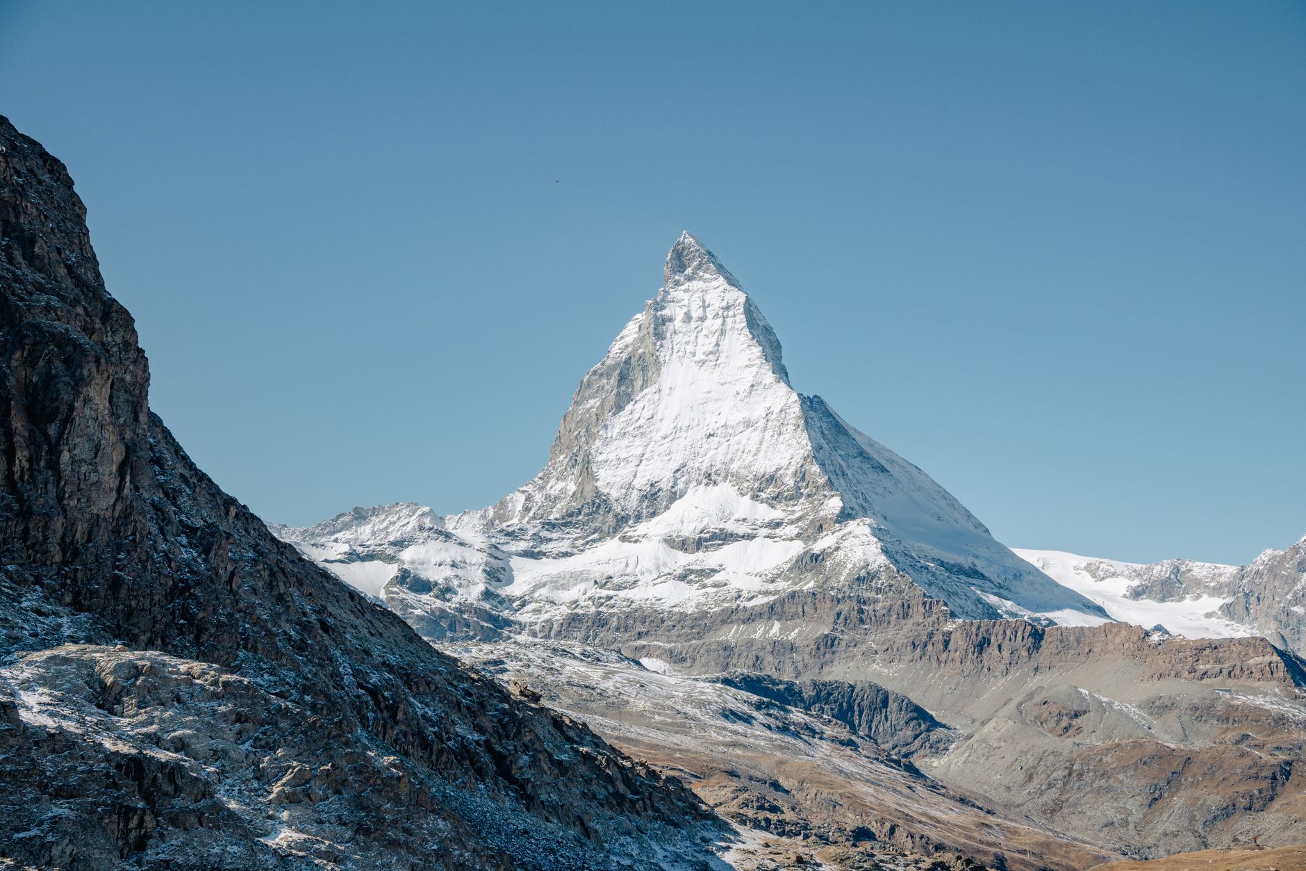 Breathtaking view of the Matterhorn peak surrounded by rocky and snowy mountainous terrain in Zermatt, Switzerland.