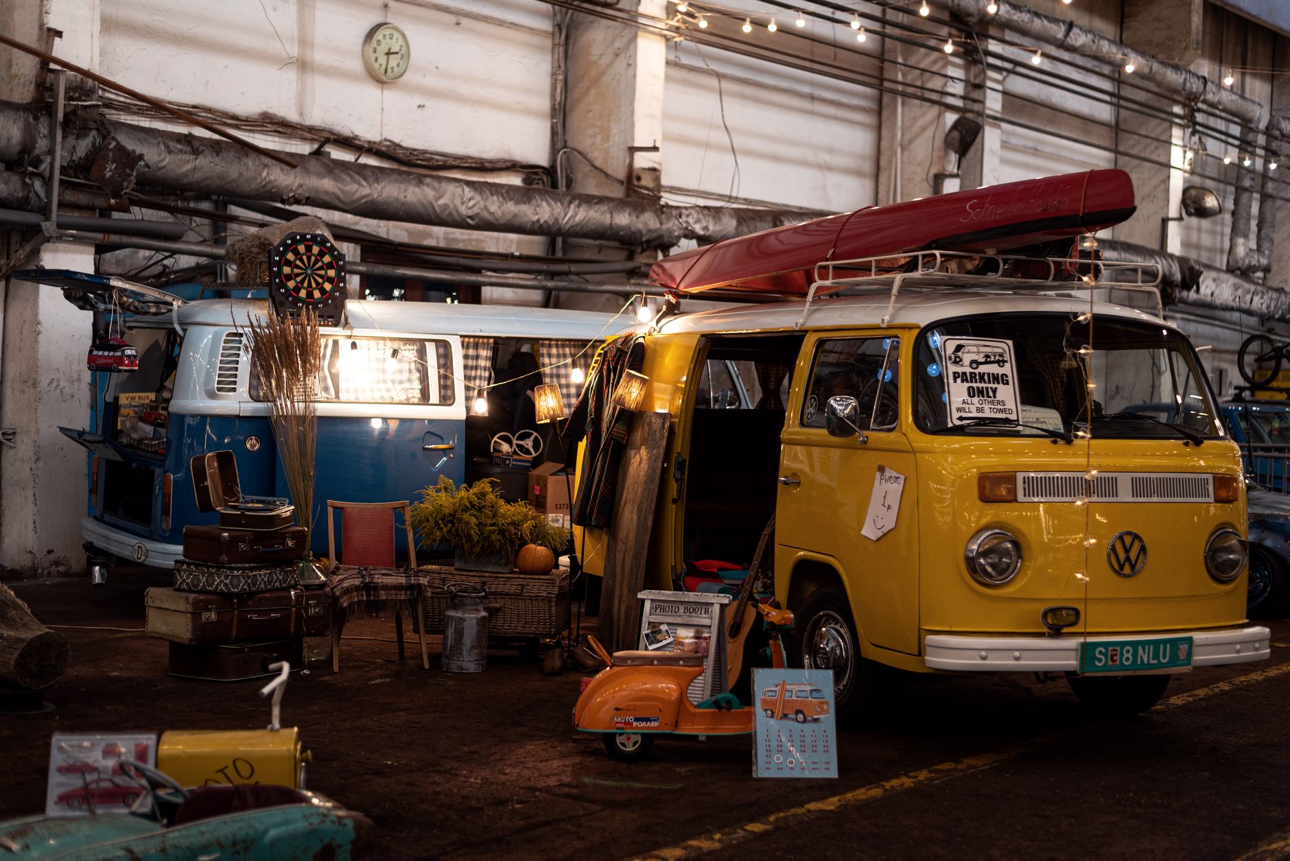 Explore classic camper vans in a retro indoor exhibition with vintage decor and warm lighting.