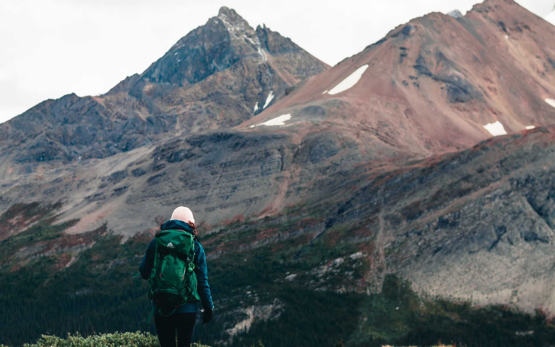 A person with a backpack hikes through stunning mountainous terrain, epitomizing adventure and outdoor exploration.