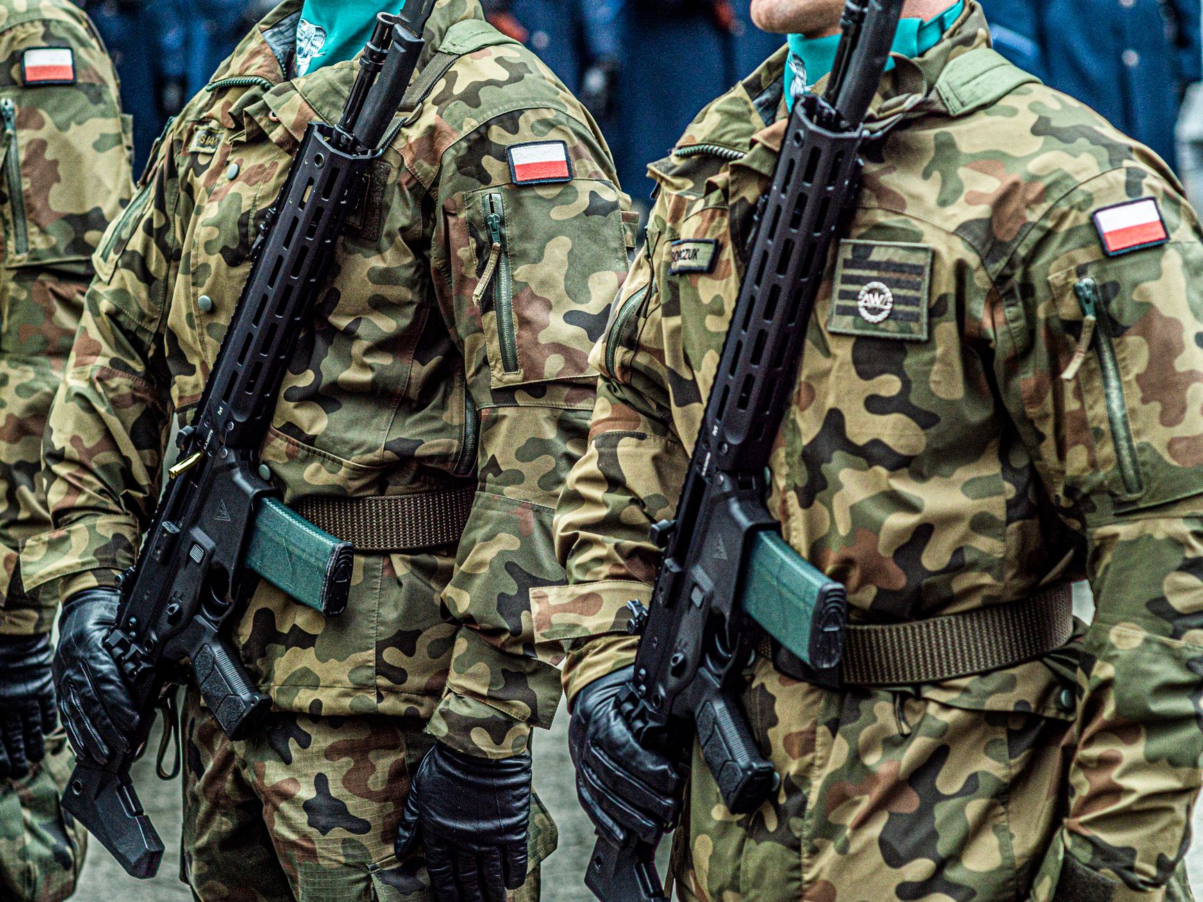 Polish soldiers in uniform standing in formation with rifles, showcasing military discipline.