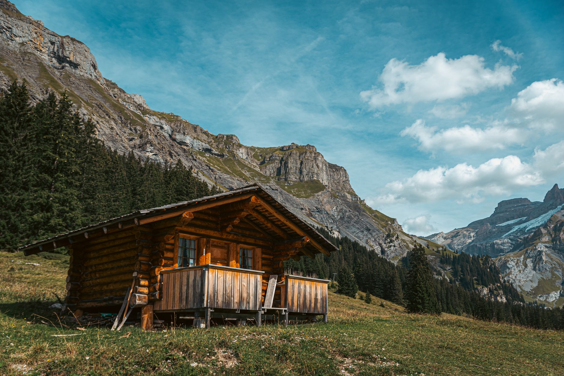 Cozy wooden cabin nestled in a picturesque mountain landscape, surrounded by evergreen trees.
